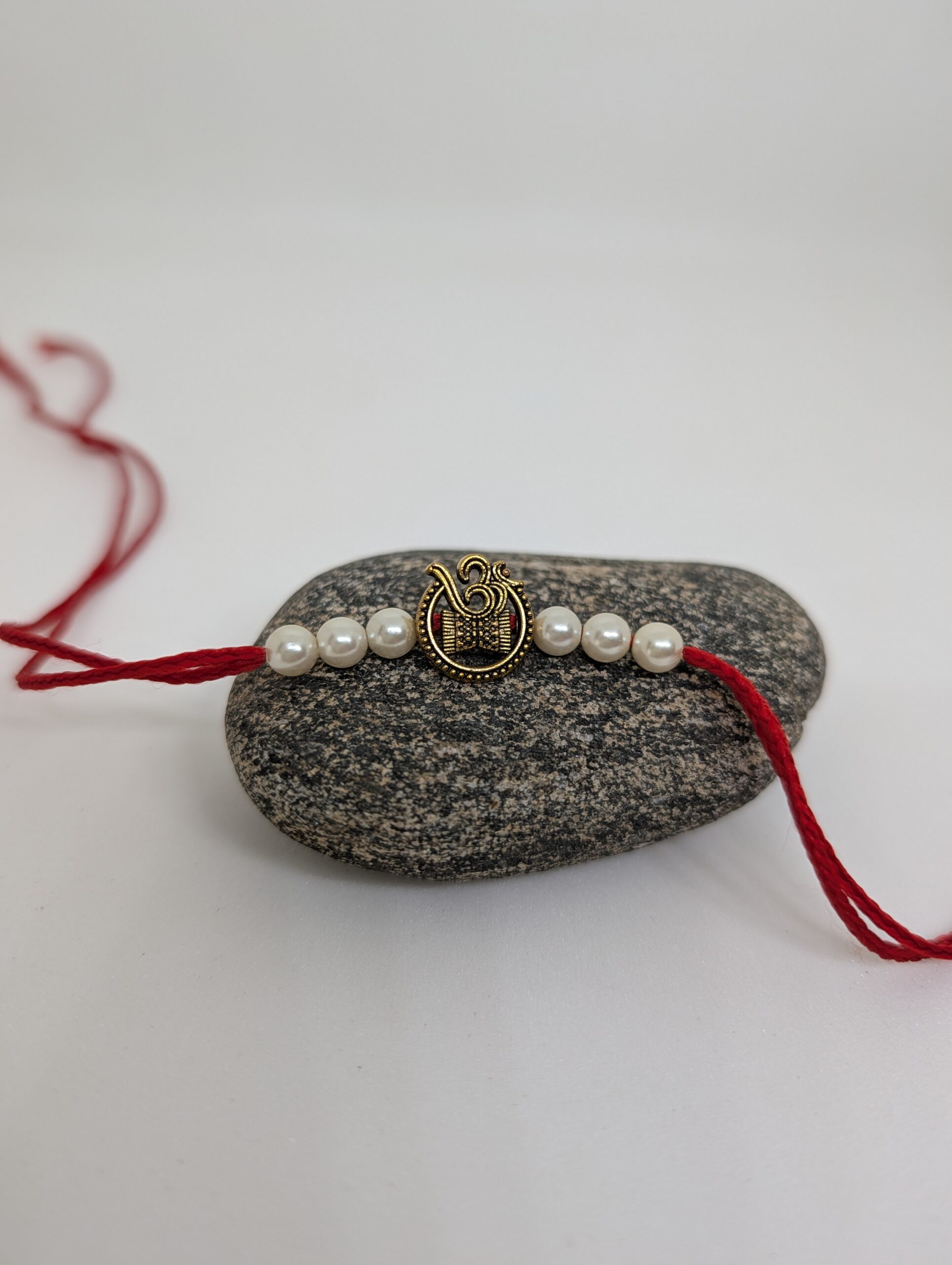Om Rakhi With White Pearls